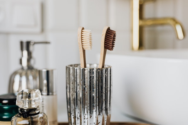 Bamboo toothbrushes in a glass in a bathroom